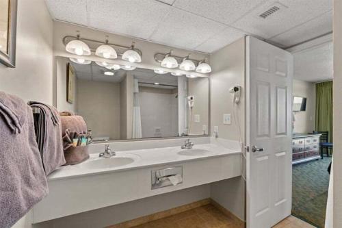 a bathroom with a sink and a large mirror at Spacious 2 bedroom Direct Ocean Front Condo, Corner Unit, Balconies HSS 5th FL in Myrtle Beach