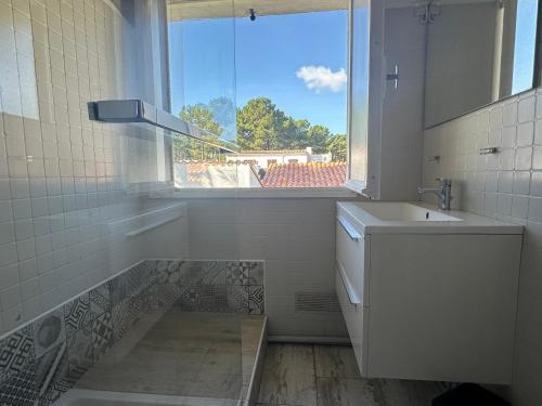 une salle de bain blanche avec un lavabo et une fenêtre dans l'établissement Villa 4 chambres La Palmyre avec Patio et WIFI - FR-1-705-96, aux Mathes