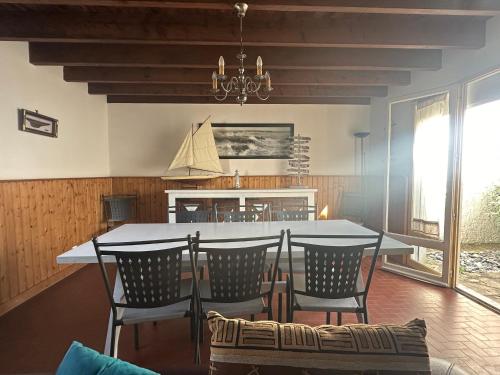 une salle à manger avec une table et des chaises blanches dans l'établissement Villa 4 chambres La Palmyre avec Patio et WIFI - FR-1-705-96, aux Mathes