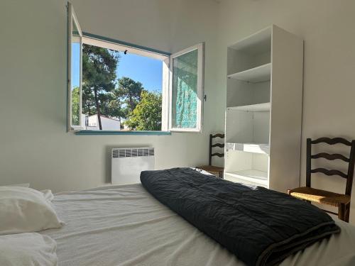 une chambre avec un lit avec une grande fenêtre dans l'établissement Villa 4 chambres La Palmyre avec Patio et WIFI - FR-1-705-96, aux Mathes