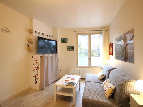 - un salon avec un canapé et un réfrigérateur dans l'établissement Studio 26m² au centre de La Bourboule avec WIFI, proche des Thermes - FR-1-415-157, à La Bourboule