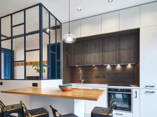 une cuisine avec des placards en bois et un comptoir en bois dans l'établissement Appartement rénové T4 avec parking, Bayonne centre historique - FR-1-783-46, à Bayonne