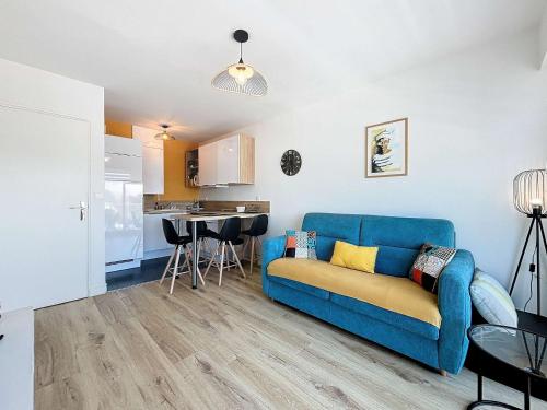 un salon avec un canapé bleu et une cuisine dans l'établissement Appartement cosy avec balcon, port de Granville, 2 pers. - FR-1-361-550, à Granville