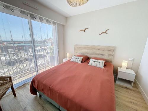une chambre avec un grand lit et une grande fenêtre dans l'établissement Appartement cosy avec balcon, port de Granville, 2 pers. - FR-1-361-550, à Granville