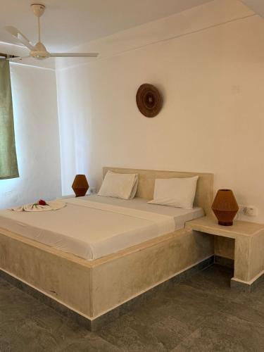 a bed in a room with two lamps on it at Paje White House in Paje