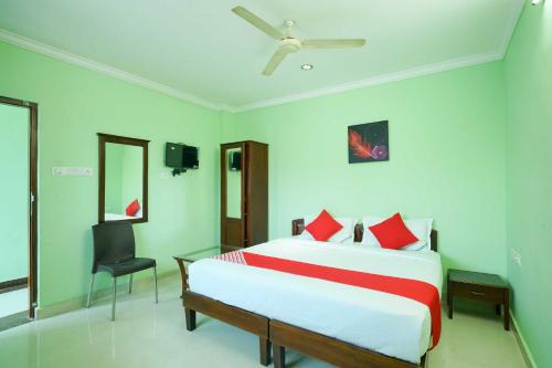a bedroom with a large bed and a chair at Hotel O Infopark Kochi Malabar Plaza Residency in Ernakulam