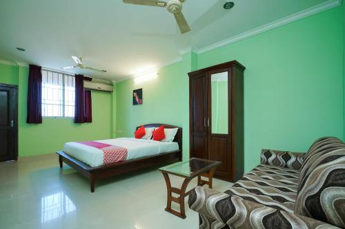 a living room with a bed and a couch at Hotel O Infopark Kochi Malabar Plaza Residency in Ernakulam