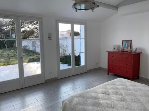 - une chambre avec un lit et des portes coulissantes en verre dans l'établissement Maison de vacances à l'Épine - 4 personnes - Près de la plage - FR-1-823-45, à LʼÉpine