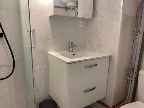une salle de bain blanche avec un lavabo et des toilettes dans l'établissement T2 Mezzanine - 5/6 Pers - Piscine & Parking - Saint-Pierre-La-Mer - FR-1-795-18, à Fleury