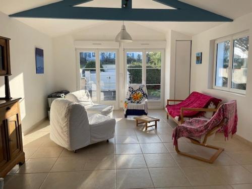 Elle comprend un salon doté d'un mobilier blanc et d'un plafond bleu. dans l'établissement Maison de vacances à l'Épine - 4 personnes - Près de la plage - FR-1-823-45, à LʼÉpine