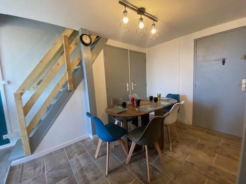 une salle à manger avec une table et des chaises et un escalier dans l'établissement T2 Mezzanine - 5/6 Pers - Piscine & Parking - Saint-Pierre-La-Mer - FR-1-795-18, à Fleury
