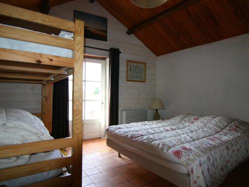 une chambre avec deux lits superposés et une fenêtre dans l'établissement Maison rénovée avec jardin, près de la plage - 5 pers, parking - FR-1-823-48, à La Guérinière