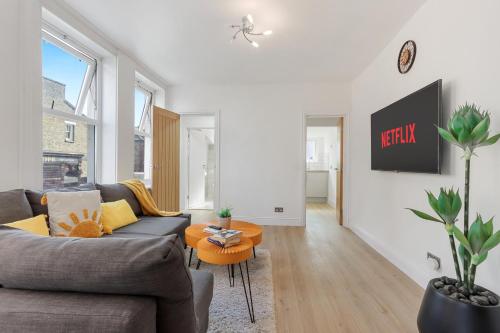 a living room with a couch and a table at LUX 1 Bed Flat next to Station in Tooting in London
