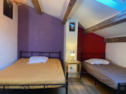 - 2 lits dans une chambre dotée d'un mur violet dans l'établissement T2 Mezzanine - 5/6 Pers - Piscine & Parking - Saint-Pierre-La-Mer - FR-1-795-18, à Fleury