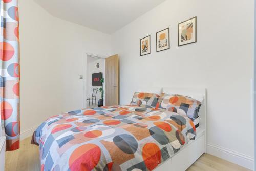 a bedroom with a bed with a colorful comforter at LUX 1 Bed Flat next to Station in Tooting in London
