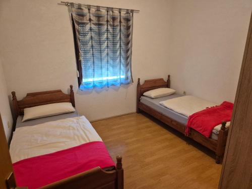 two twin beds in a room with a window at Apartman Pecara in Široki Brijeg