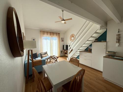 Il comprend une cuisine et un salon avec une table et un escalier. dans l'établissement Appartement 6 pers au port avec parking privatif - FR-1-197-613, à Les Sables-dʼOlonne