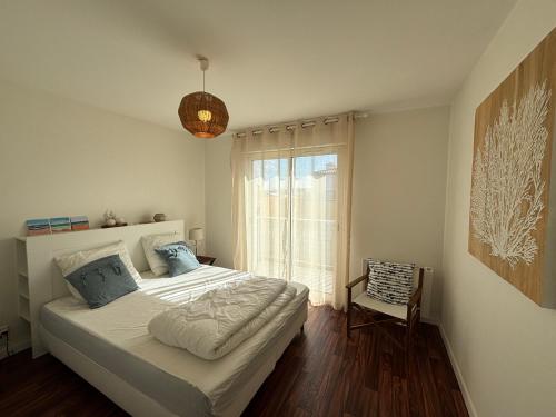 une chambre avec un grand lit et une fenêtre dans l'établissement Appartement 6 pers au port avec parking privatif - FR-1-197-613, à Les Sables-dʼOlonne