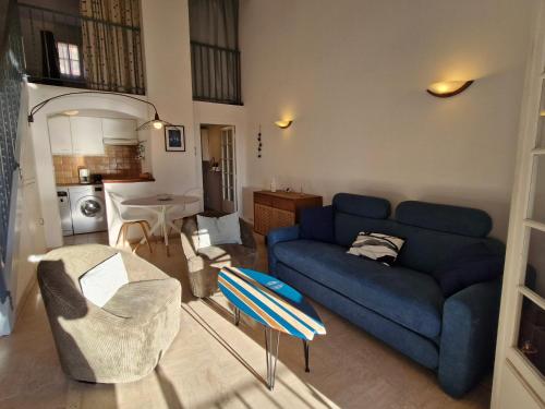 un salon avec un canapé bleu et une table dans l'établissement Appartement avec mezzanine, piscine, parking et près de la mer à Sainte-Maxime - FR-1-780-81, à Sainte-Maxime