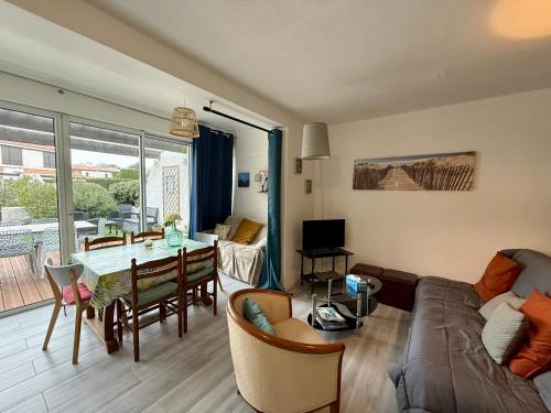 - un salon avec un canapé et une table à manger dans l'établissement Maison avec jardinet proche plage et parking - FR-1-652-58, à Saint-Jean-de-Monts