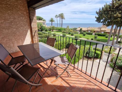 un balcon avec une table et des chaises et l'océan dans l'établissement Appartement avec mezzanine, piscine, parking et près de la mer à Sainte-Maxime - FR-1-780-81, à Sainte-Maxime