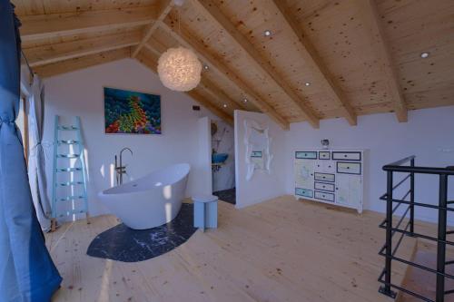 a bathroom with a large tub in a room with wooden ceilings at Villa Biankura in Blato