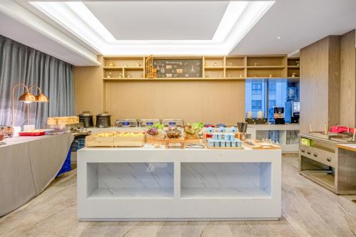 a kitchen with a counter with food on it at Kunming Meihao Lizhi Hotel Cuihu Park Yunnan University Hospital Branch in Kunming