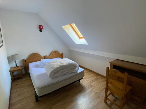 - une chambre avec un lit doté de draps blancs et une lucarne dans l'établissement Duplex calme avec piscine et balcon près de Super-Besse - FR-1-814-40, à Besse-et-Saint-Anastaise