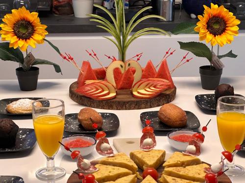 a table with food and orange juice and flowers at Calatabarca B&B in Tabarca