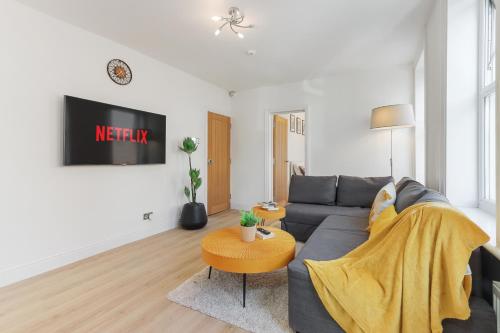 a living room with a gray couch and a table at LUX 1 Bed Flat next to Station in Tooting in London