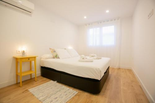 ein weißes Schlafzimmer mit einem Bett und einem Fenster in der Unterkunft La casita de Sacaba Beach in Málaga