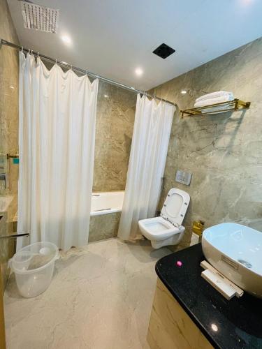 a bathroom with a toilet and a sink and a tub at Glitz T2 Grand-Next to Intl Airport in Mumbai