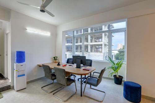 an office with a table and chairs and a large window at Acasa Suites - ITPL Whitefield, Near Manipal Hospital in Bengaluru
