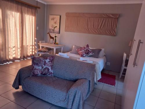 a living room with a couch and a bed at 109 Mauser Avenue in Pretoria