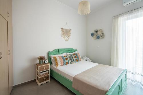 a bedroom with a green bed and a window at Georgia's House in Galatas