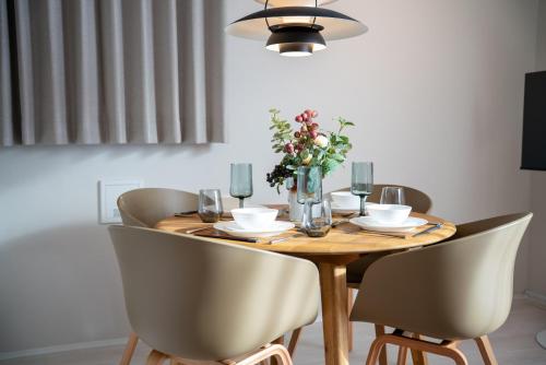a wooden table with chairs and a vase of flowers at Ken's Place Azabu-Juban in Tokyo