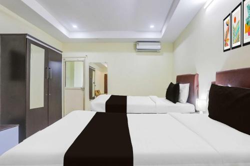 a bedroom with two beds with white and black at Hotel O Nellore Subbareddy Government Hospital Hotel Rama Royal in Nellore