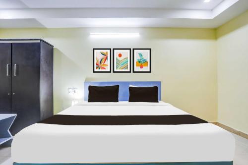 a bedroom with a large white bed with two pillows at Hotel O Nellore Subbareddy Government Hospital Hotel Rama Royal in Nellore
