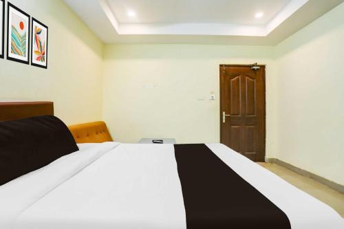 a bedroom with a bed with a black and white blanket at Hotel O Nellore Subbareddy Government Hospital Hotel Rama Royal in Nellore