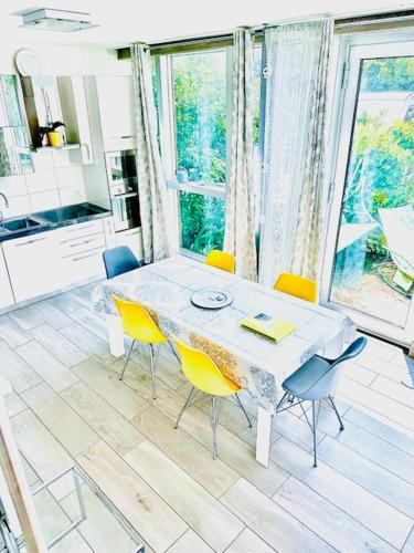 a dining room with a white table and yellow chairs at Dock House in Marone