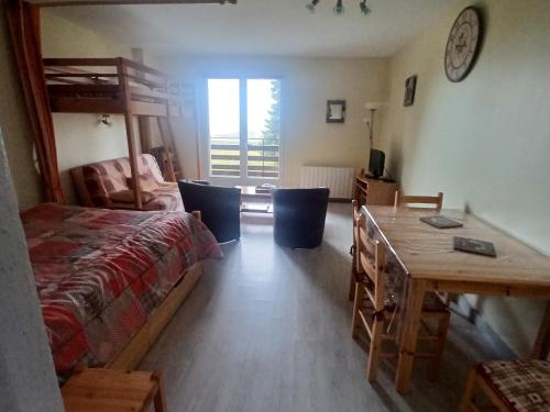 a bedroom with a bed and a desk and a table at Studio calme avec parking à Super Besse - FR-1-814-125 in Besse-et-Saint-Anastaise