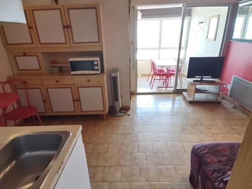 une cuisine avec un évier et un salon dans l'établissement Appartement spacieux 6 pers, centre ville Valras-Plage, à 10m de la plage - FR-1-781-67, à Valras-Plage