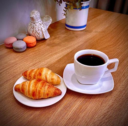 a cup of coffee and two croissants on a table at Five Star Westlake 1st-4th Floors Hotel & Serviced Apartment in Hanoi