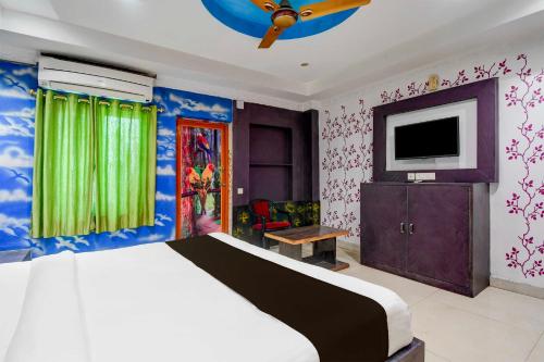 a bedroom with a bed and a flat screen tv at Hotel O Tamando Jagannath Temple Hotel Blue Royal in Bhubaneshwar