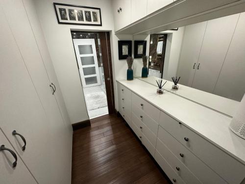 a bathroom with white cabinets and a large mirror at Unique Luxury Home in the heart of London. Air conditioned with private garden in London