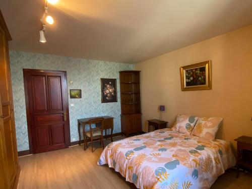 a bedroom with a bed and a table in it at Maison familiale avec piscine privée à Saint-Gaultier - FR-1-591-752 in Saint-Gaultier