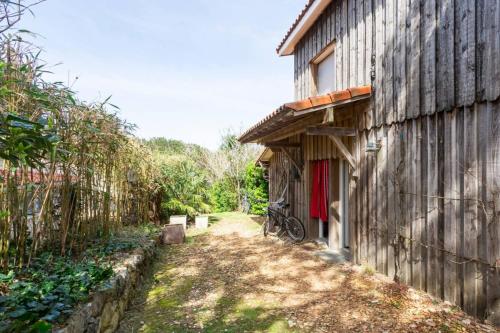 a bike is parked next to a building at La Cabane de Bébert - Marie en Lys in Cap-Ferret