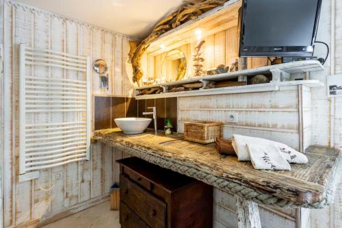 a bathroom with a counter with a sink and a tv at La Cabane de Bébert - Marie en Lys in Cap-Ferret