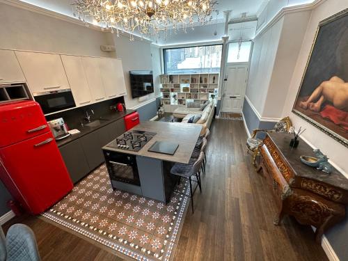 a kitchen and living room with a red stove top oven at Unique Luxury Home in the heart of London. Air conditioned with private garden in London