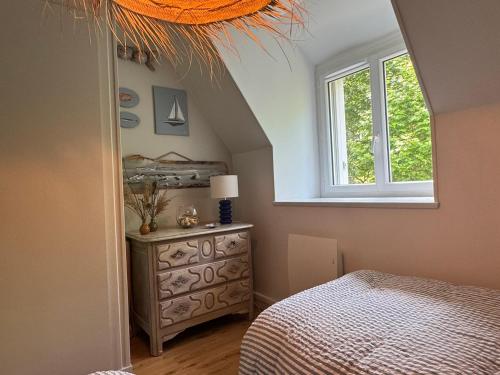 a bedroom with a bed and a window and a dresser at Appartement Duplex 2 Pièces Centre-Ville avec Balcon et Internet Inclus - FR-1-487-383 in Cabourg